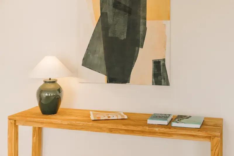 Teak console, ceramic lamp and an abstract painting