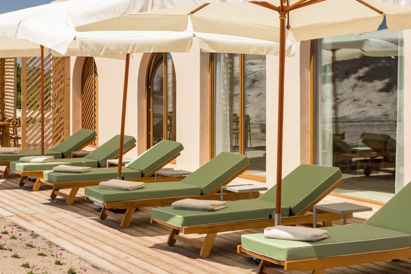 Sun loungers and parasols along the villa’s arched glass doors